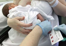 Un sanitario realiza la prueba del talón a un recién nacido en el Hospital Donostia.