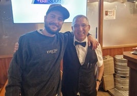 El camarero de El Asador El Bierzo de Barcelona, Víctor Muñoz, en imagen con el cantante Manuel Carrasco.
